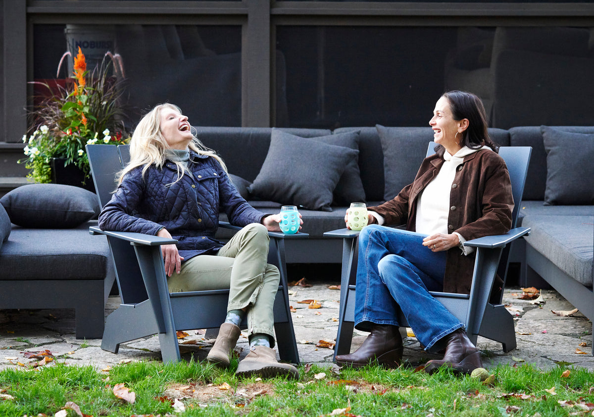 founders heather and keri laughing while enjoying coffee outside